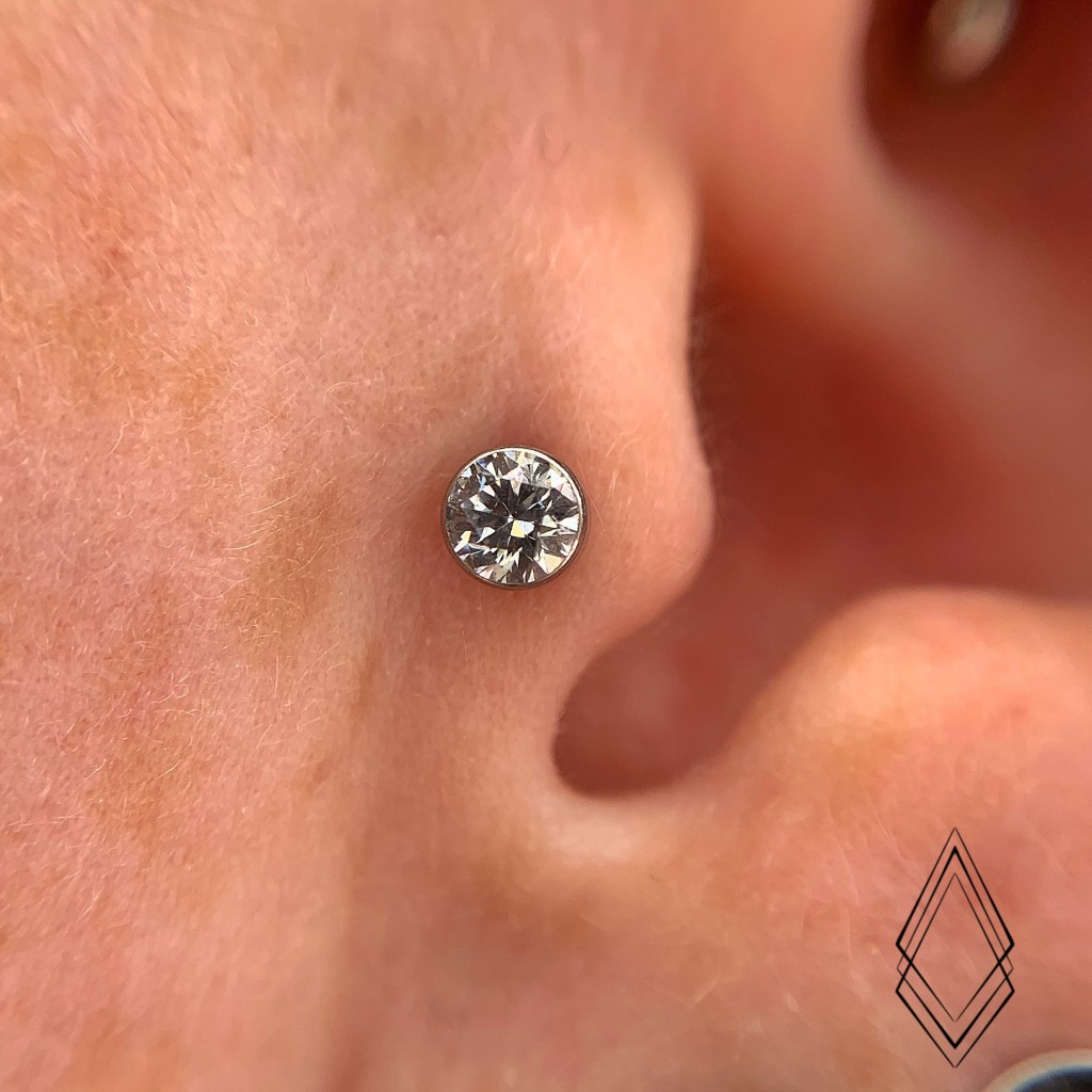 Tragus Piercing with a White CZ Bezel-set